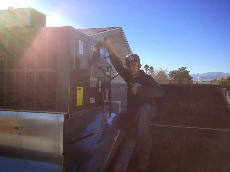 HVAC technician performing HVAC Inspection on a rooftop unit in Lombard